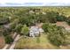 Expansive aerial shot showcasing a two-story house nestled among dense trees with a well-maintained lawn at 32615 Windy Oak St, Sorrento, FL 32776