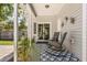 Cozy back porch with rocking chairs, outdoor rug and sliding glass door to interior at 32615 Windy Oak St, Sorrento, FL 32776