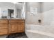 Bathroom features a soaking tub, light-colored tiled walls, and a wood vanity with sink at 32615 Windy Oak St, Sorrento, FL 32776