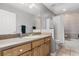 Bright bathroom featuring a large mirror, wood vanity, and a shower/tub combo with tile surround at 32615 Windy Oak St, Sorrento, FL 32776