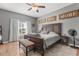 Comfortable bedroom boasts a ceiling fan, a window with natural light, and wood-look flooring at 32615 Windy Oak St, Sorrento, FL 32776
