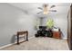 Neutral bedroom featuring carpeted floors, a ceiling fan, and a work area with natural lighting at 32615 Windy Oak St, Sorrento, FL 32776