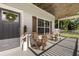 Inviting front porch with wooden rocking chairs, welcome wreath and wooden ceiling at 32615 Windy Oak St, Sorrento, FL 32776