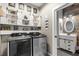 Functional laundry room featuring modern appliances and decorative shelving, with access to a half bath at 32615 Windy Oak St, Sorrento, FL 32776