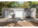 Large outbuilding with two garage doors, bench and gravel driveway surrounded by trees at 32615 Windy Oak St, Sorrento, FL 32776