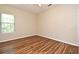 A bedroom featuring hardwood floors, a window, and neutral walls, offering a simple and calming space at 3441 Hickory Creek Rd, Deltona, FL 32738