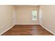 A spacious bedroom featuring wood floors, neutral walls, and a window overlooking the pool area at 3441 Hickory Creek Rd, Deltona, FL 32738