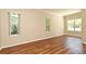 Bedroom with hardwood floors and natural light from windows overlooking greenery at 3441 Hickory Creek Rd, Deltona, FL 32738
