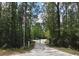 Gated driveway entrance to a wooded property with an American flag at 3441 Hickory Creek Rd, Deltona, FL 32738