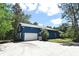 Side view of the blue, two-story home featuring a two-car garage and a well-maintained, grassy yard at 3441 Hickory Creek Rd, Deltona, FL 32738