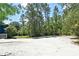 View of the driveway, side yard and wooded boundary at 3441 Hickory Creek Rd, Deltona, FL 32738
