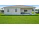 Backyard featuring a covered patio with outdoor seating and lush green grass at 3588 Dahlia Dr, Haines City, FL 33844
