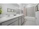 Bathroom with double sinks, gray cabinets, and a shower with a curtain at 3588 Dahlia Dr, Haines City, FL 33844