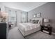 A well-lit bedroom with a neutral color palette, dresser, nightstands, and large windows at 3588 Dahlia Dr, Haines City, FL 33844
