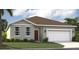 Charming single-story home with a well-manicured lawn, two-car garage, and welcoming front entrance at 3588 Dahlia Dr, Haines City, FL 33844