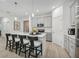 A modern kitchen features gray cabinets, a center island with seating, and stainless steel appliances at 3588 Dahlia Dr, Haines City, FL 33844