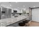 Bright kitchen featuring white cabinets, stainless steel appliances, and a granite countertop island at 3747 S Atlantic Ave # 2050, Daytona Beach, FL 32118