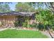 Landscaped front yard with green grass, garden beds, and a charming brick and gated entrance at 396 Newton, Longwood, FL 32779
