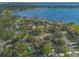 Aerial view of a home with a swimming pool in a lakeside neighborhood bordered by lush trees at 4011 Teriwood Ave, Orlando, FL 32812
