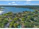 Scenic aerial capture of a residential area near a large lake with scattered clouds above at 4011 Teriwood Ave, Orlando, FL 32812