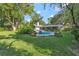 Expansive backyard with a sparkling pool, ample greenery, and seating area, ideal for outdoor entertainment at 4011 Teriwood Ave, Orlando, FL 32812