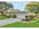 Charming single-story home with an attached garage, mature trees, and a long concrete driveway at 4011 Teriwood Ave, Orlando, FL 32812