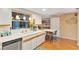 Bright kitchen showcasing white cabinets, a breakfast bar, and stainless steel dishwasher at 4011 Teriwood Ave, Orlando, FL 32812