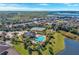 Expansive aerial view of a community with a pool, tennis courts, and beautiful landscaping near the lake at 408 Egret Place Dr, Winter Garden, FL 34787
