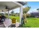 Covered patio with ceiling fan, overlooking a green yard and a tranquil water view at 408 Egret Place Dr, Winter Garden, FL 34787