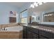 Bathroom featuring a tub, granite counters, wood cabinets, and ample natural light at 408 Egret Place Dr, Winter Garden, FL 34787