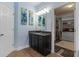 Bright bathroom featuring blue walls, granite counters, wood cabinets, and access to a walk-in closet at 408 Egret Place Dr, Winter Garden, FL 34787