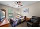 Comfortable bedroom features soft carpeting, a ceiling fan and a large window at 408 Egret Place Dr, Winter Garden, FL 34787