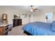 Large bedroom with carpet, ceiling fan, a dresser and a comfortable bed with blue bedding at 408 Egret Place Dr, Winter Garden, FL 34787