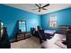 Bright bedroom featuring a ceiling fan, blue accent wall, desk and window at 408 Egret Place Dr, Winter Garden, FL 34787
