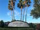 Elegant Johns Lake Pointe entrance sign under palm trees against a beautiful blue sky at 408 Egret Place Dr, Winter Garden, FL 34787