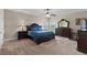 A spacious primary bedroom featuring a large bed, carpet, and two dressers with lamps at 408 Egret Place Dr, Winter Garden, FL 34787