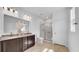 Bathroom featuring a double vanity, granite countertops, and a glass-enclosed shower at 415 Overpool Ave, Davenport, FL 33896