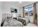 Cozy bedroom with twin beds, soft lighting, and a view of the landscaped yard at 415 Overpool Ave, Davenport, FL 33896