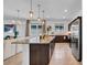 Modern kitchen featuring a large island with a granite countertop, stainless steel appliances, and an adjacent living area at 415 Overpool Ave, Davenport, FL 33896