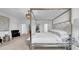 Elegant main bedroom featuring a four-poster bed, stylish decor, and ample natural light at 415 Overpool Ave, Davenport, FL 33896
