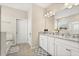 Bathroom featuring double vanity with granite counters, cabinetry, a large mirror, and updated fixtures at 449 Halter Dr, Apopka, FL 32712