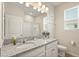 Bright bathroom features a granite countertop with double sinks, framed mirror, and ample natural light from the window at 449 Halter Dr, Apopka, FL 32712