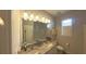 Bathroom with double sinks, a large mirror, and granite countertops, creating a clean and stylish space at 449 Halter Dr, Apopka, FL 32712