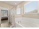 Bright bathroom featuring a soaking tub with tile surround and a glass-enclosed shower at 449 Halter Dr, Apopka, FL 32712
