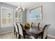 Elegant dining room featuring a wood table, upholstered chairs, stylish light fixture, and window views at 449 Halter Dr, Apopka, FL 32712