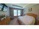 Comfortable main bedroom with tray ceilings, a TV, and large windows at 449 Halter Dr, Apopka, FL 32712