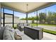 Screened patio featuring neutral wicker furniture, a center table, and a view of the backyard at 449 Halter Dr, Apopka, FL 32712