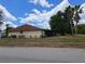 Single-story home with lawn, mature trees, and screened in lanai at 5005 Lindsay Ct, Orlando, FL 32821