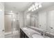 Bathroom featuring double vanity sinks, granite countertops, and dual glass enclosed shower stalls at 5006 Caspian St, St Cloud, FL 34771