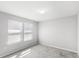 Bedroom with neutral carpet, walls, and two windows at 5006 Caspian St, St Cloud, FL 34771